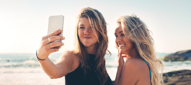 girls at the beach taking a selfie